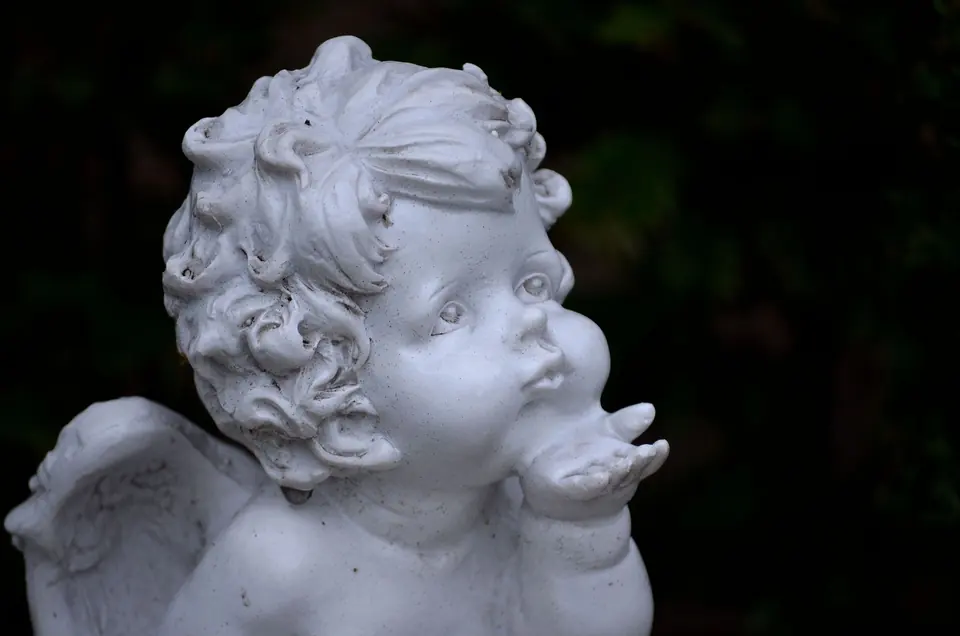 Serene Cherub-Skulptur in einem Garten in Bocholt, die filigrane Details und engelsgleiche Form zeigt.