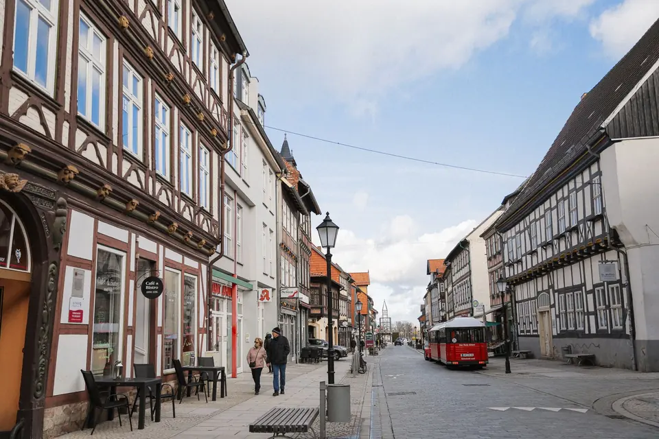 Eine malerische Straße mit Fachwerkhäusern und Fußgängern in einer deutschen Stadt.