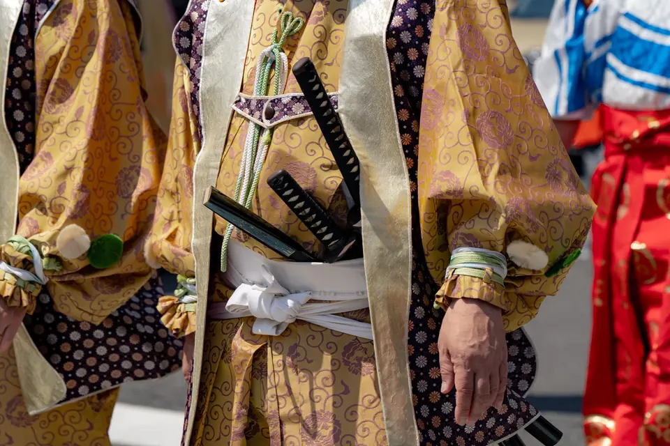 Nahaufnahme traditioneller japanischer Festtagskostüme und Schwerter, leuchtende Farben in Tokio, Japan.